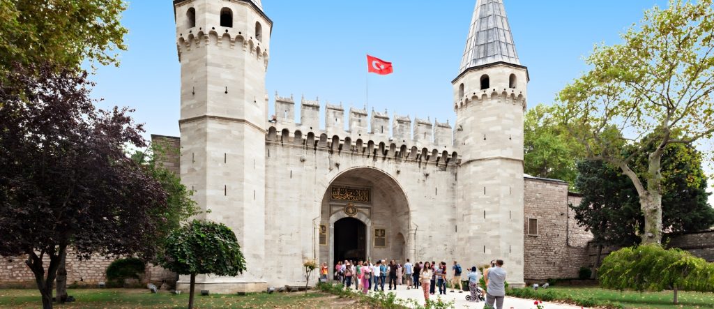A view of the conical-roofed octagonal towers of the Gate of Salutation under a clear Istanbul sky.