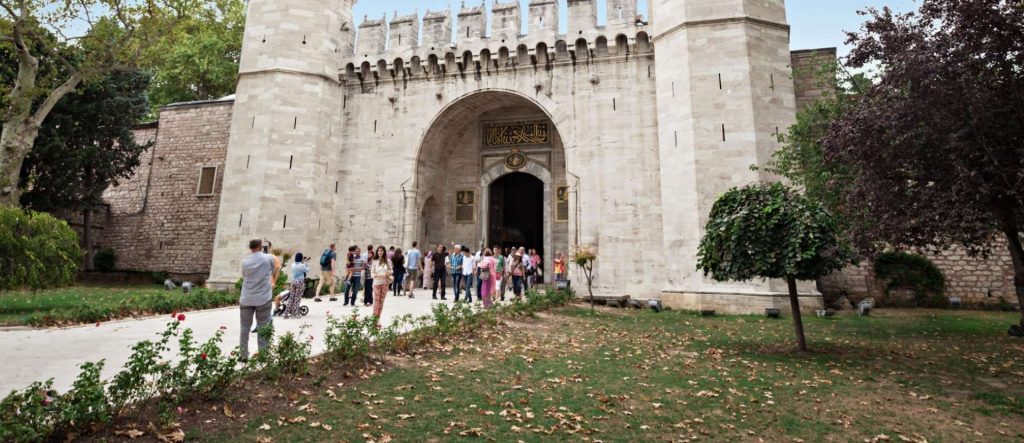 Visitors at the Gate of Salutation, planning their Topkapi Palace visit and exploring options for tickets and seeing other Istanbul landmarks. With Museum Pass cards.