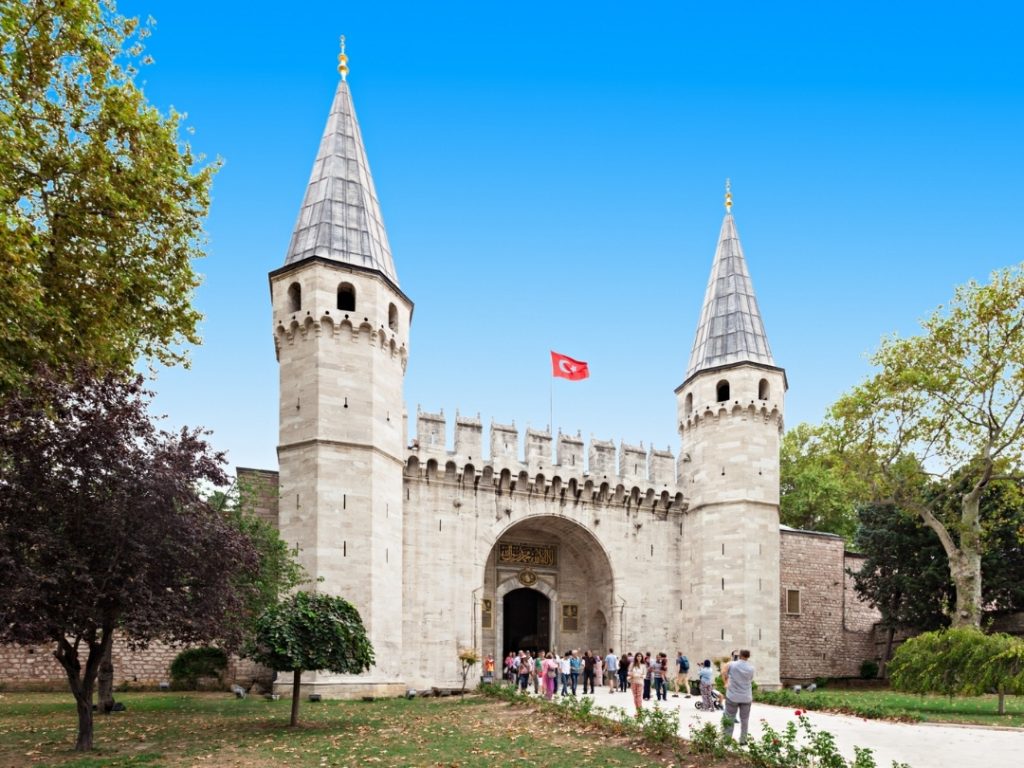 A perspectived view of the conical-roofed octagonal towers of the Gate of Salutation under a clear Istanbul sky.